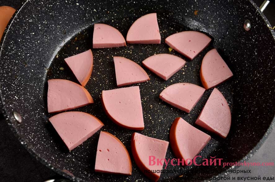 картофель перекладываю в форму и отправляю в сковороду нарезанную на небольшие слайсы вареную колбасу